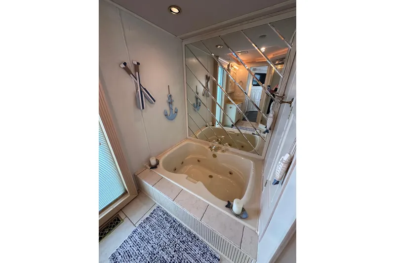 Slide: The Image of Luxurious bathroom with jacuzzi tub, mirrored wall, nautical decor, and candles in Fantasy 18x82, 2001. - 16