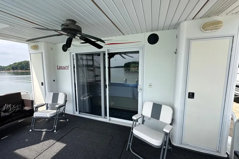 Slide: The Image of Covered deck area on a 2001 Fantasy 18x82 houseboat with chairs and ceiling fan. - 19