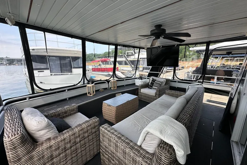 Slide: The Image of Luxurious 2001 Fantasy 18x82 houseboat interior with wicker furniture and lake view. - 2