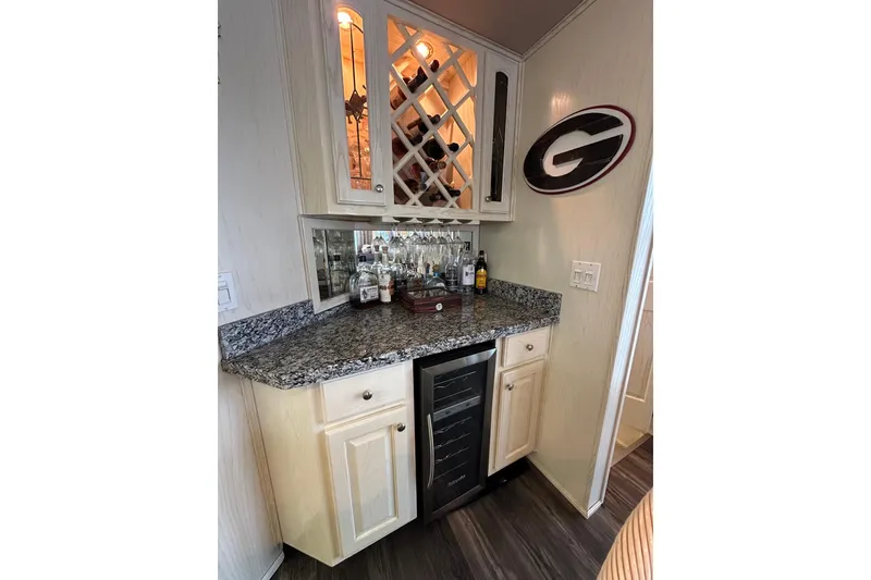 Slide: The Image of Elegant home bar with granite countertop, wine storage, and decorative wall sign in a cozy corner. - 7