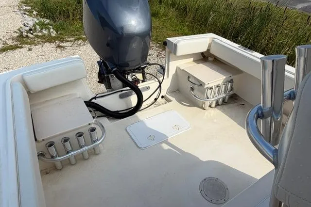 Slide: The Image of 2007 Parker 23 SE boat deck with motor and rod holders, near grassy shoreline. - 18