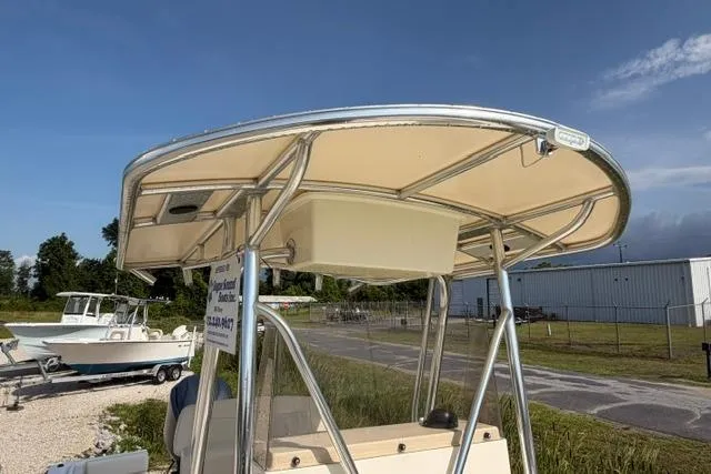 Slide: The Image of 2007 Parker 23 SE boat with T-top, parked outdoors near a fence and other boats. - 7