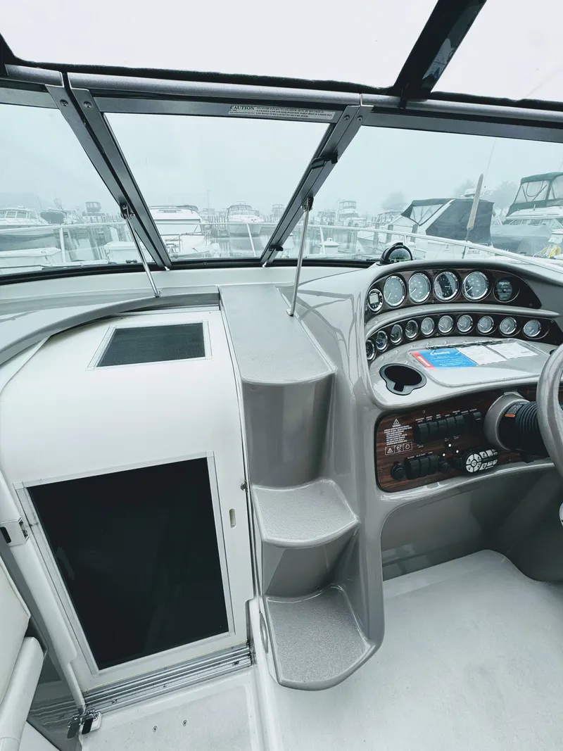 Slide: The Image of The cockpit of a 2001 Four Winns 298 Vista with a gray dashboard and numerous instruments. - 13