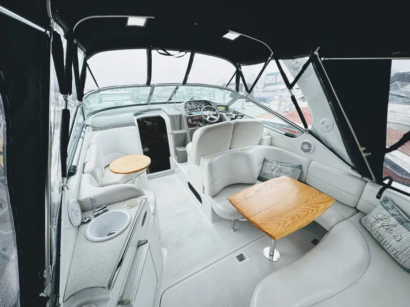 Slide: The Image of Interior of a 2001 Four Winns 298 Vista with white seating and wooden tables. - 15