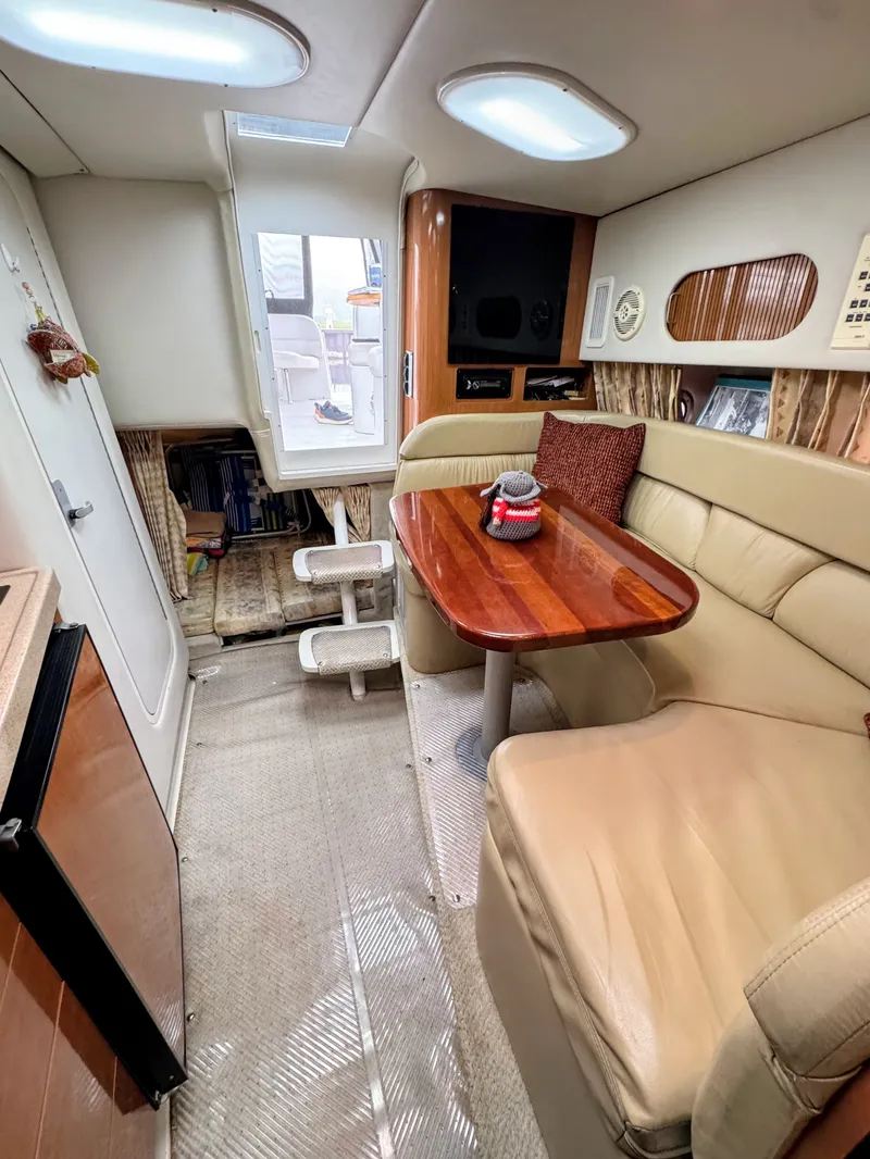 Slide: The Image of Interior of the 2001 Four Winns 298 Vista with beige sofa, wooden table, and skylights. - 19