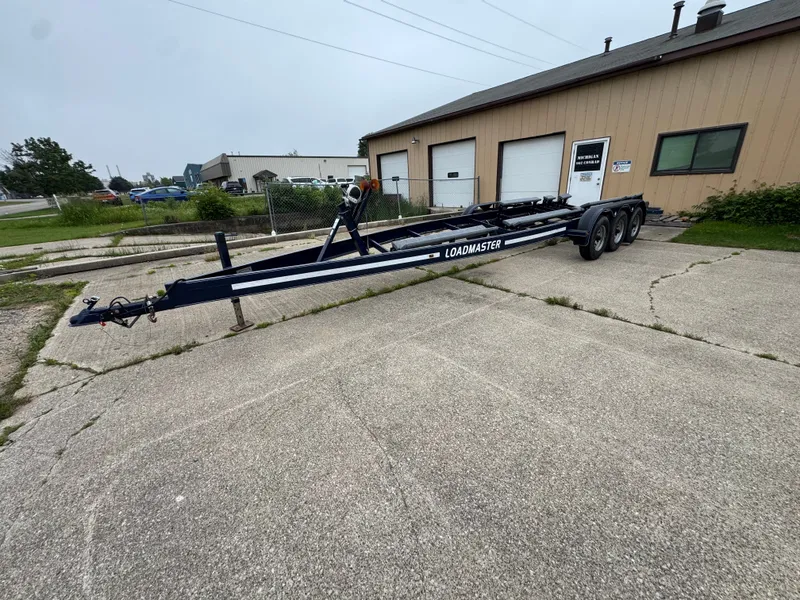 Slide: The Image of A boat trailer is parked on a concrete lot in front of a building. - 35