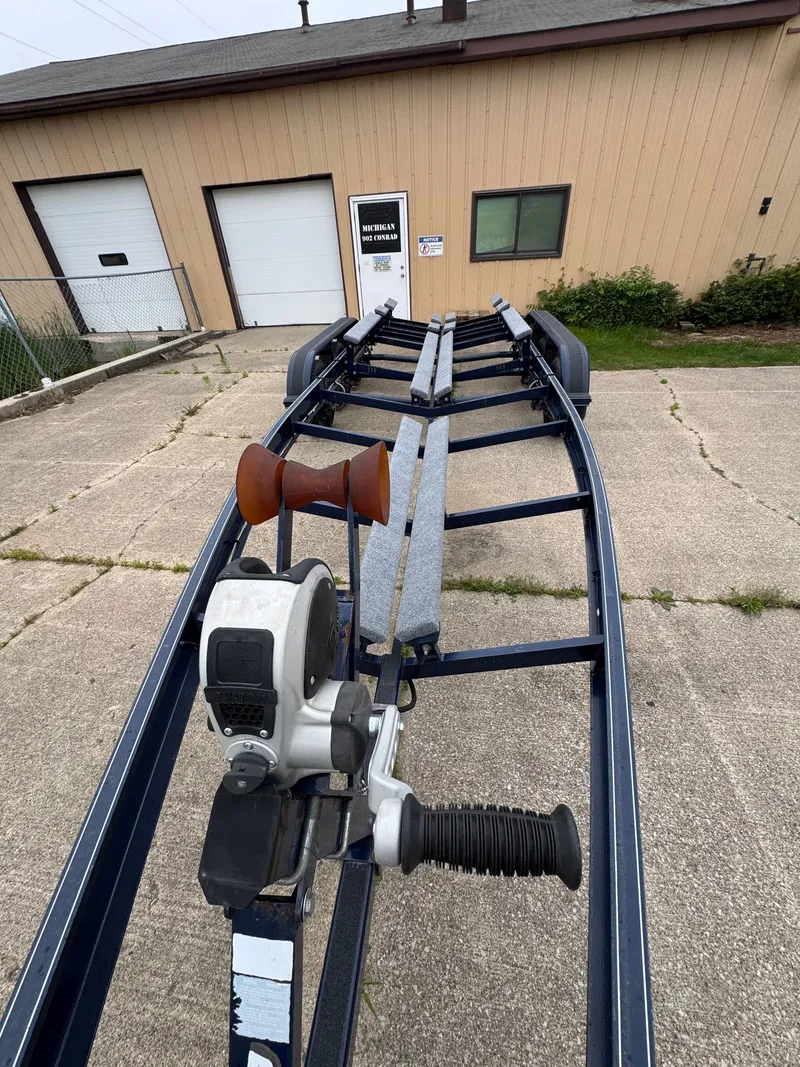 Slide: The Image of Boat trailer on concrete surface in front of a building with closed garage doors. - 36