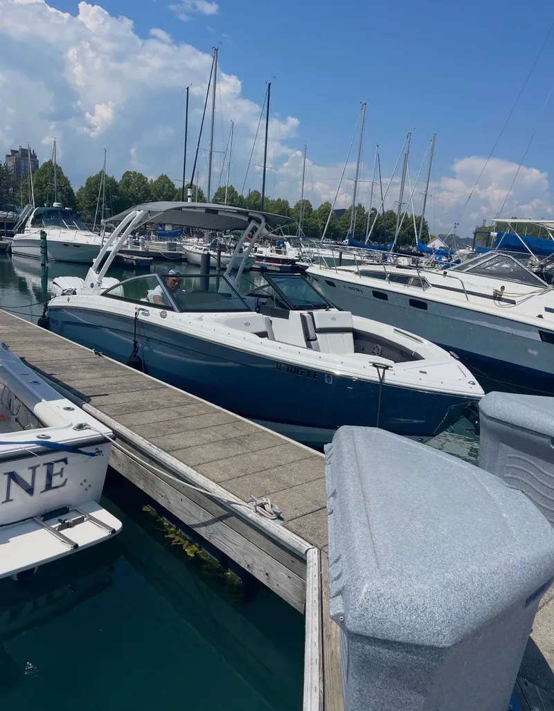 The Image of A 2023 Cobalt R8 boat docked on a sunny day, surrounded by other sailboats. - 0