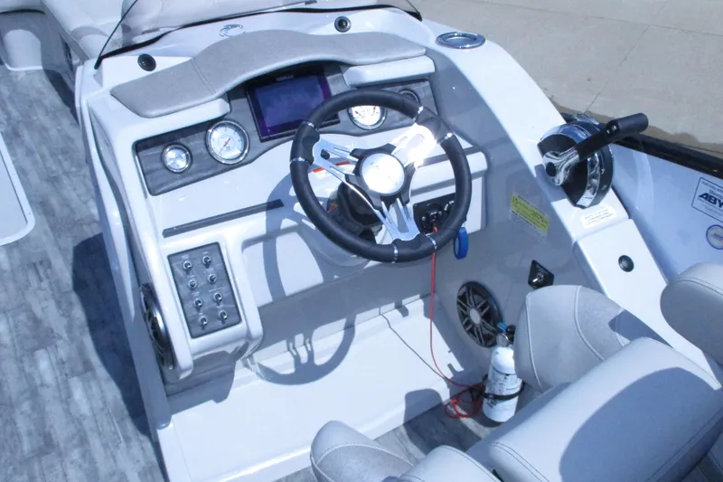 Slide: The Image of Cockpit of 2021 Crest Caribbean LX 250 SLS boat with steering wheel and controls. - 13