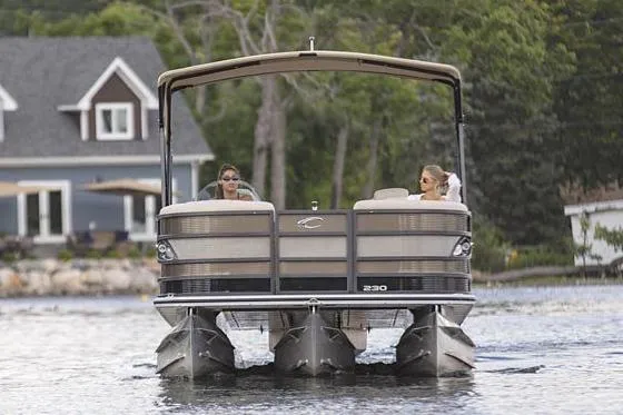 Slide: The Image of Manufacturer Provided Image: 2021 Crest Caribbean LX 250 SLS pontoon boat on a lake with two people. - 2