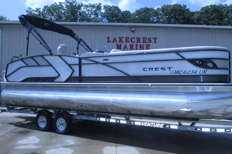 The Image of 2021 Crest Caribbean LX 250 SLS pontoon boat on trailer at Lakecrest Marine. - 0