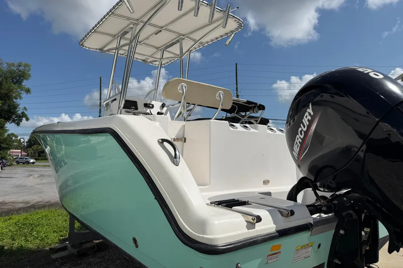 Slide: The Image of 2023 Aquasport 2200 Center Console boat with Mercury outboard motor, parked outdoors. - 3