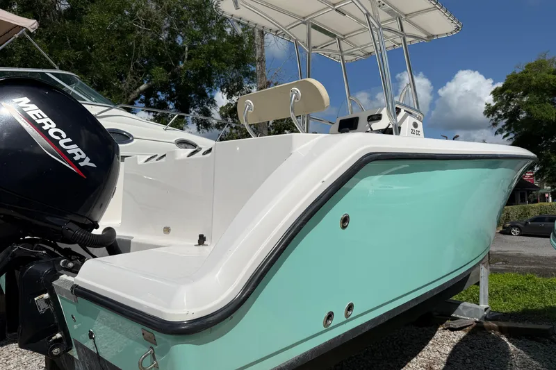 Slide: The Image of 2023 Aquasport 2200 Center Console boat with Mercury engine, light blue hull, and T-top. - 4