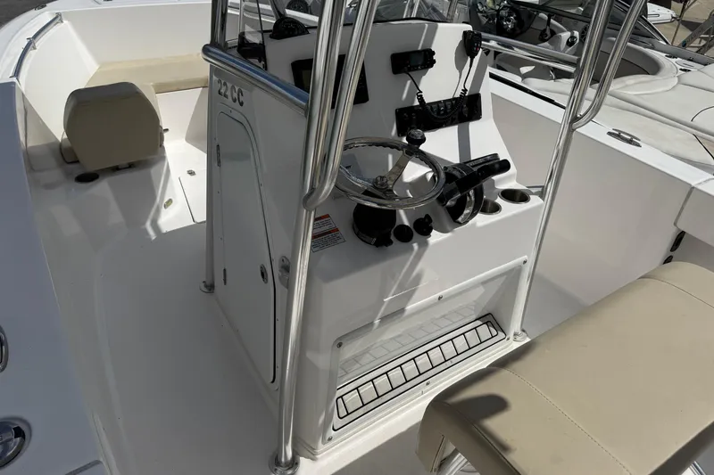 Slide: The Image of 2023 Aquasport 2200 Center Console boat interior with steering wheel and seating. - 6