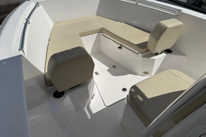 Slide: The Image of 2023 Aquasport 2200 Center Console boat interior with beige seating and white deck. - 9