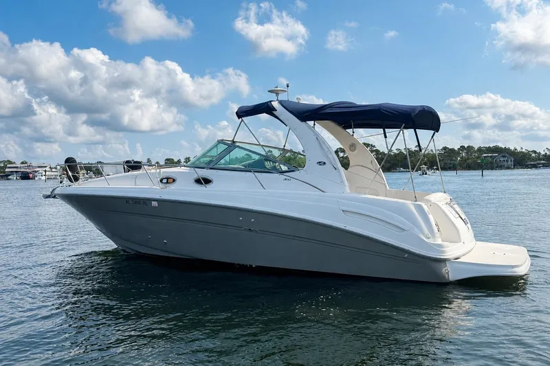Slide: The Image of 2006 Sea Ray 300 Sundancer boat on calm water under a blue sky. - 4