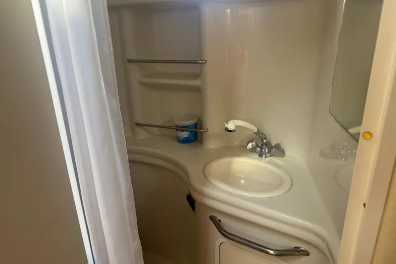 Slide: The Image of Bathroom interior of 2006 Sea Ray 300 Sundancer yacht with sink and storage shelves. - 7