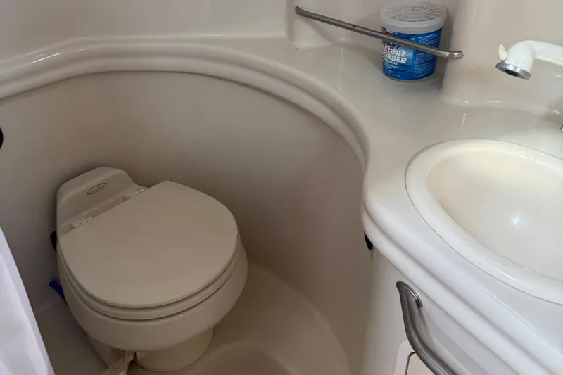 Slide: The Image of Compact bathroom in 2006 Sea Ray 300 Sundancer boat with toilet and sink. - 8