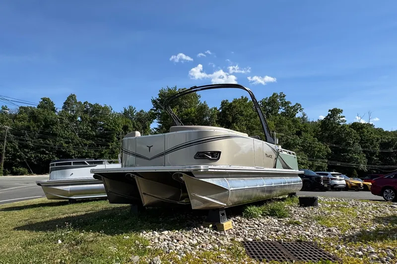 The Image of 2026 Tahoe Pontoon LTZ Entertainer 23 on display outdoors, surrounded by trees and parked cars. - 0