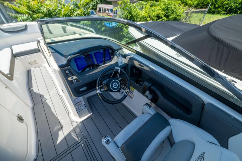 Slide: The Image of 2025 Chaparral 250 OSX boat cockpit with modern steering and digital displays. - 10