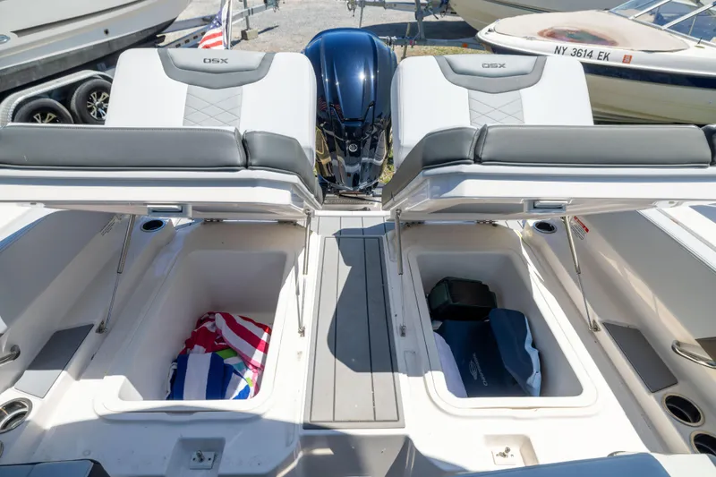 Slide: The Image of 2025 Chaparral 250 OSX boat with open storage compartments and seating. - 15
