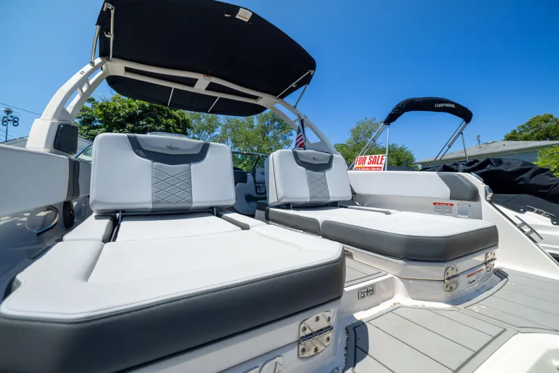 Slide: The Image of 2025 Chaparral 250 OSX boat interior with cushioned seating, under a clear blue sky. - 18