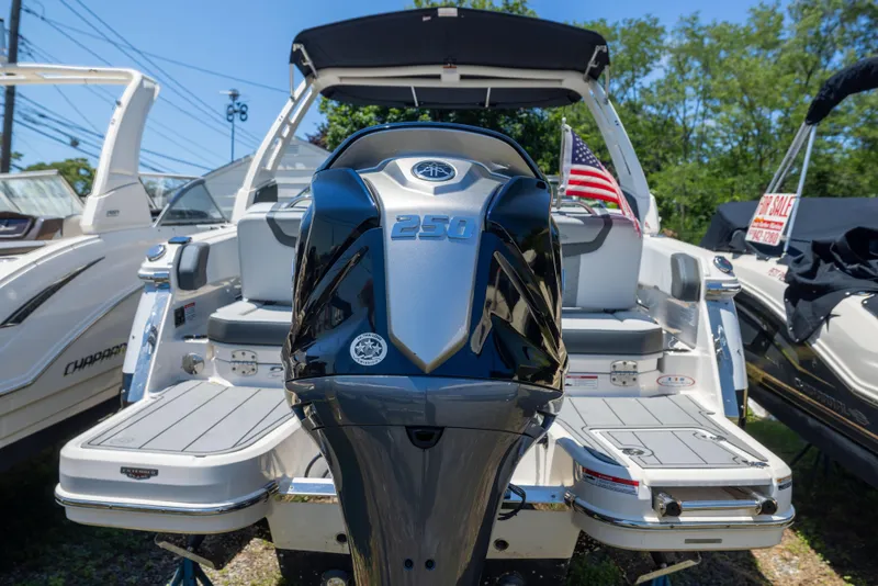 Slide: The Image of 2025 Chaparral 250 OSX boat with powerful engine, displayed outdoors with American flag. - 2