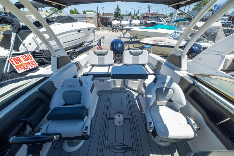 Slide: The Image of 2025 Chaparral 250 OSX boat interior with seating and steering, for sale at marina. - 6