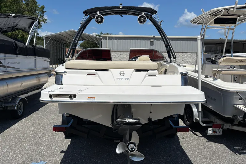 Slide: The Image of 2018 Regal 1900 ES Bowrider boat, rear view, parked between other boats. - 5