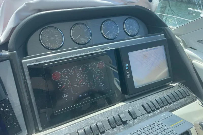 Slide: The Image of Control panel of a 2006 Sea Ray 40 Motor Yacht with gauges and navigation screens. - 12