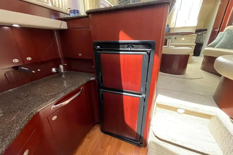 Slide: The Image of Interior of 2006 Sea Ray 40 Motor Yacht kitchen with wood cabinetry and compact refrigerator. - 39