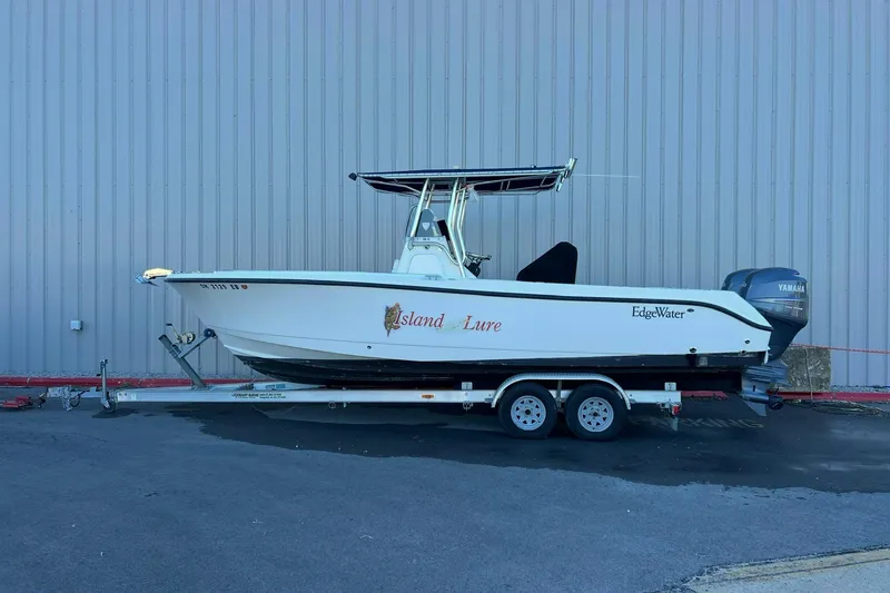 The Image of 2006 Edgewater 245CC boat on trailer, parked outdoors, featuring Yamaha outboard motor. - 0