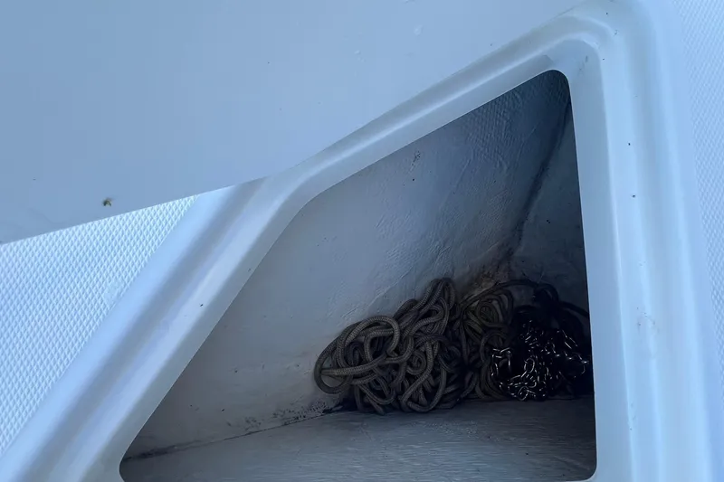 Slide: The Image of Storage compartment with coiled rope on a 2006 Edgewater 245CC boat. - 11