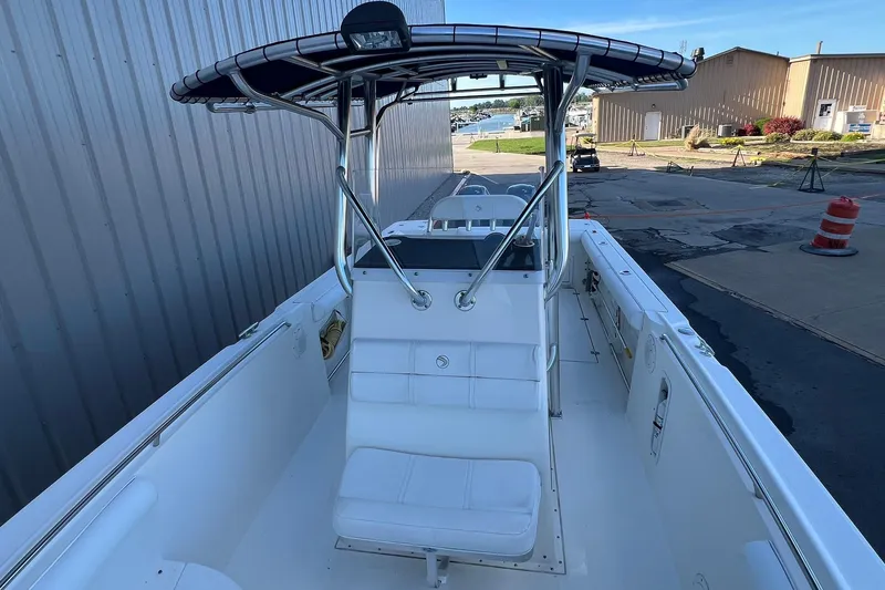 Slide: The Image of 2006 Edgewater 245CC boat with T-top, docked near industrial buildings. - 12