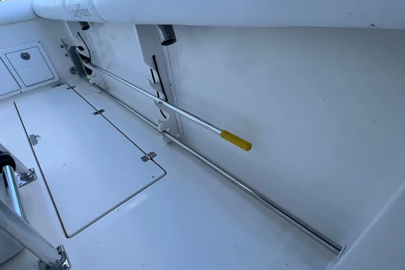 Slide: The Image of Interior view of a 2006 Edgewater 245CC boat, featuring storage compartments and rod holders. - 16