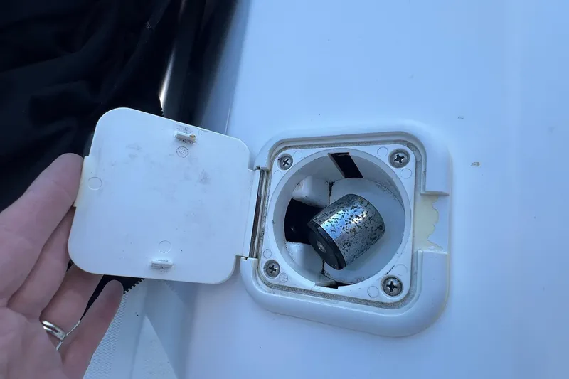 Slide: The Image of Boat fuel cap on a 2006 Edgewater 245CC, partially open with visible metal component. - 18