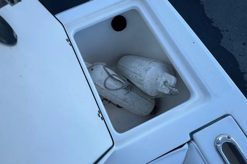 Slide: The Image of Storage compartment on a 2006 Edgewater 245CC boat with white fenders inside. - 19