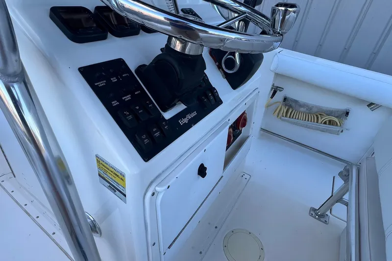 Slide: The Image of 2006 Edgewater 245CC boat console with steering wheel and control panel. - 2