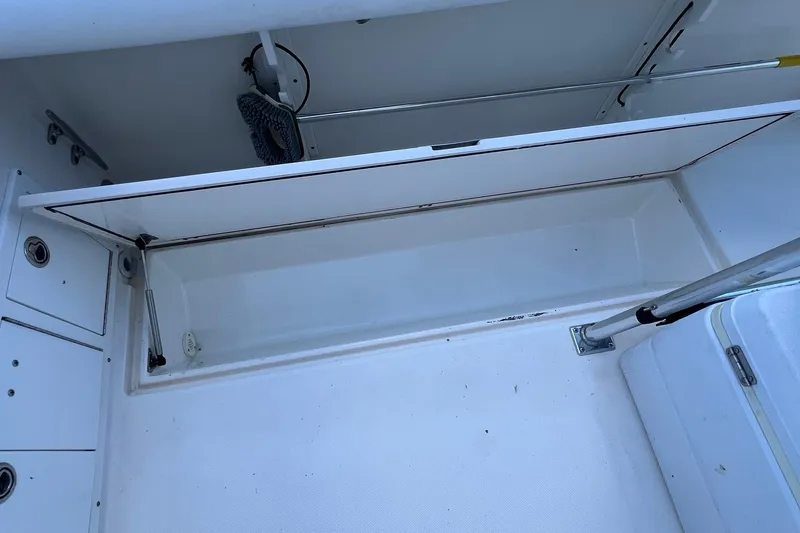 Slide: The Image of Open storage compartment on a 2006 Edgewater 245CC boat, showcasing interior space. - 20