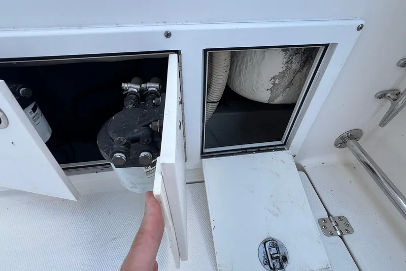 Slide: The Image of Access panel on a 2006 Edgewater 245CC boat, revealing internal components. - 21