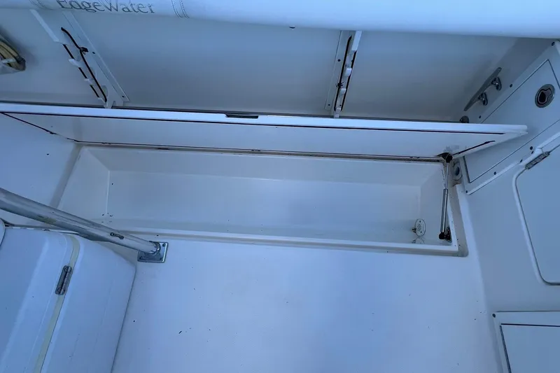 Slide: The Image of Open storage compartment on a 2006 Edgewater 245CC boat, showcasing interior space. - 22