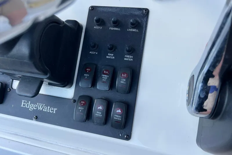 Slide: The Image of Control panel of a 2006 Edgewater 245CC boat with various switches and labels. - 23
