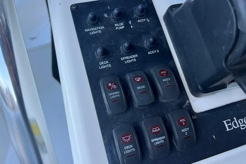 Slide: The Image of Control panel of a 2006 Edgewater 245CC boat with various switches and labels. - 24