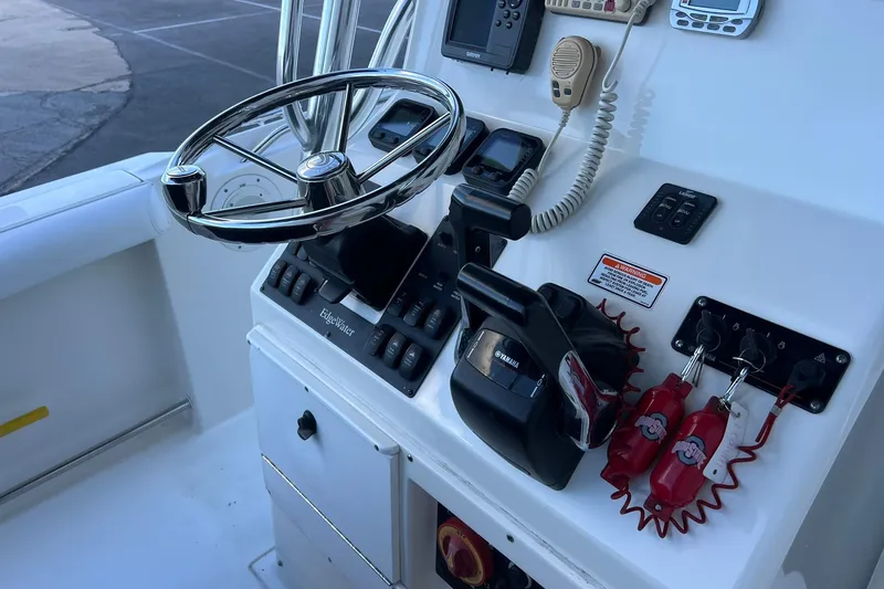 Slide: The Image of Edgewater 245CC 2006 boat console with steering wheel and controls. - 27