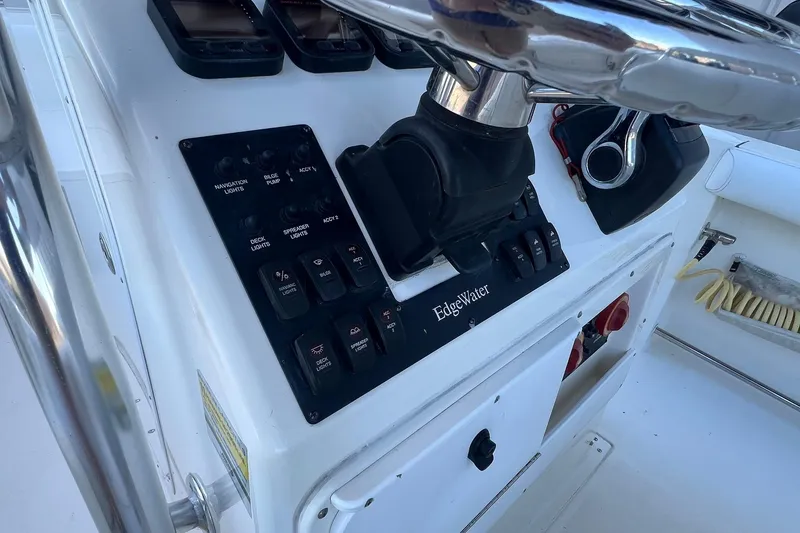 Slide: The Image of Edgewater 245CC 2006 boat dashboard with navigation controls and steering wheel. - 3