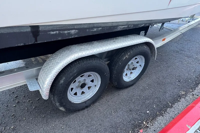 Slide: The Image of Trailer wheels of a 2006 Edgewater 245CC boat on asphalt pavement. - 32