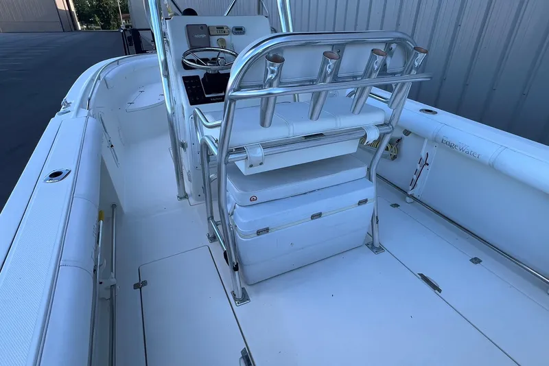 Slide: The Image of 2006 Edgewater 245CC boat interior with seating and rod holders, docked near a building. - 37