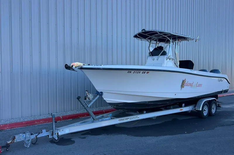 Slide: The Image of 2006 Edgewater 245CC boat on trailer, parked beside a metal building. - 38