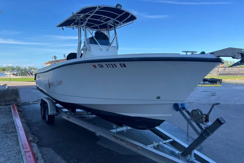 Slide: The Image of 2006 Edgewater 245CC boat on trailer, parked outdoors under clear blue sky. - 39