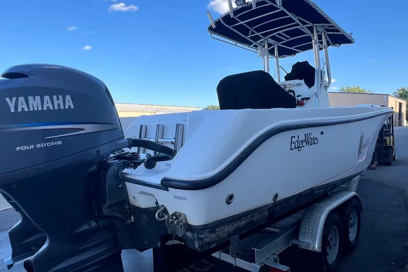 Slide: The Image of 2006 Edgewater 245CC boat with Yamaha four-stroke engine on trailer, under clear blue sky. - 42